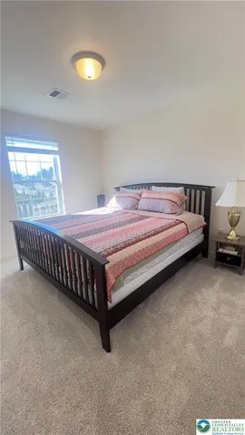 a bed sitting in a room with furniture and chandelier