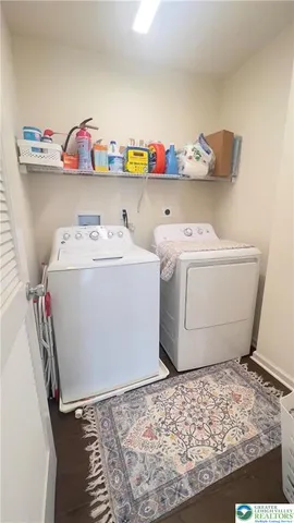 a utility room with wooden floor washer and dryer