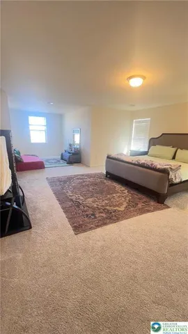 a bedroom with a bed and a lamp on dresser