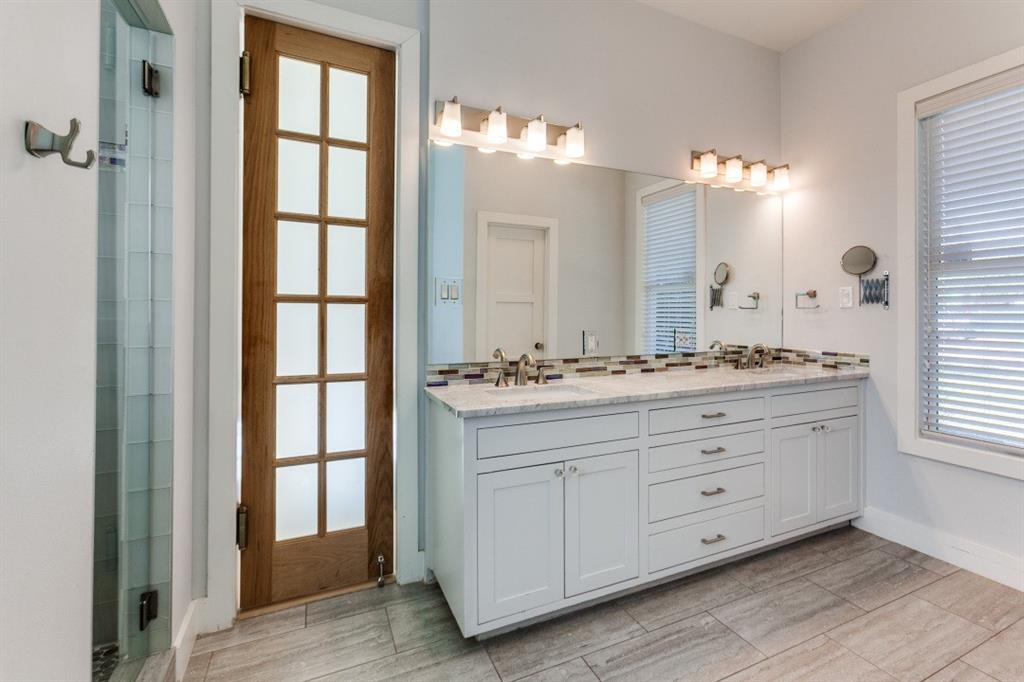 4206 Manning Lane Dallas, TX 75220 - Photo 21 of 35 a bathroom with a double vanity sink a mirror and a bathtub