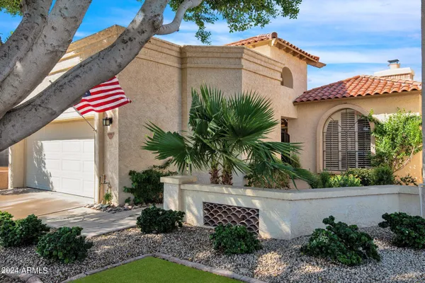 a front view of a house with a yard and potted plants