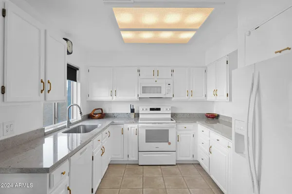 a kitchen with white cabinets appliances and sink