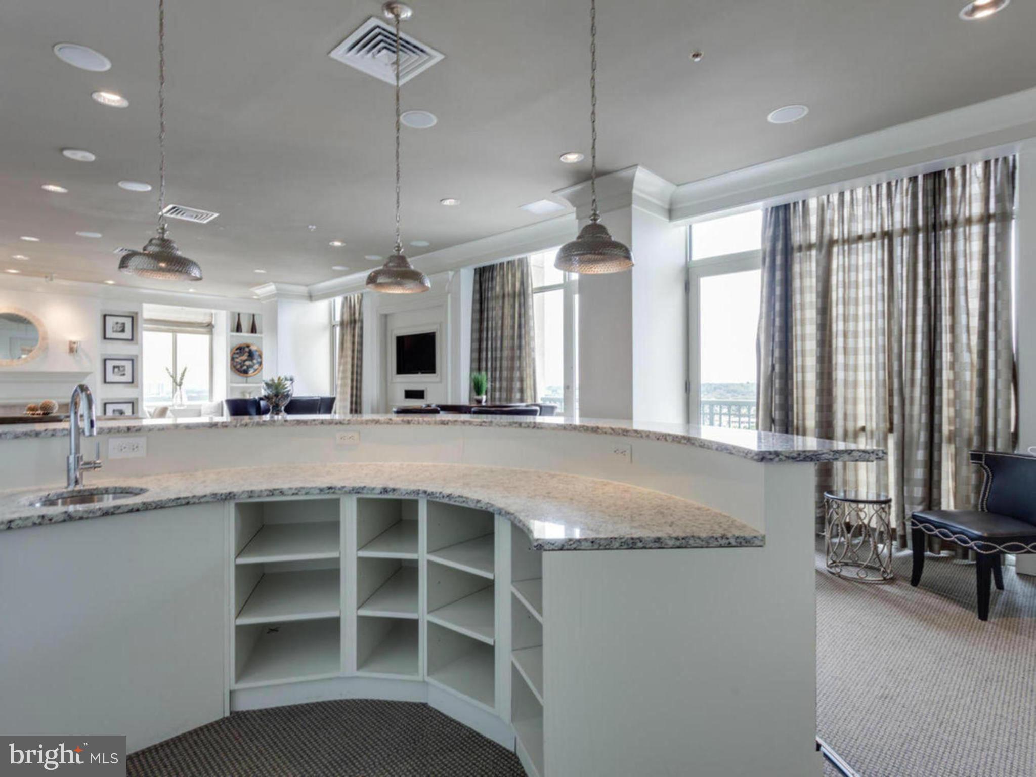 851 North Glebe Road, Unit 403 Arlington, VA 22203 - Photo 24 of 28 a large kitchen with kitchen island a large counter space a sink appliances and living room view