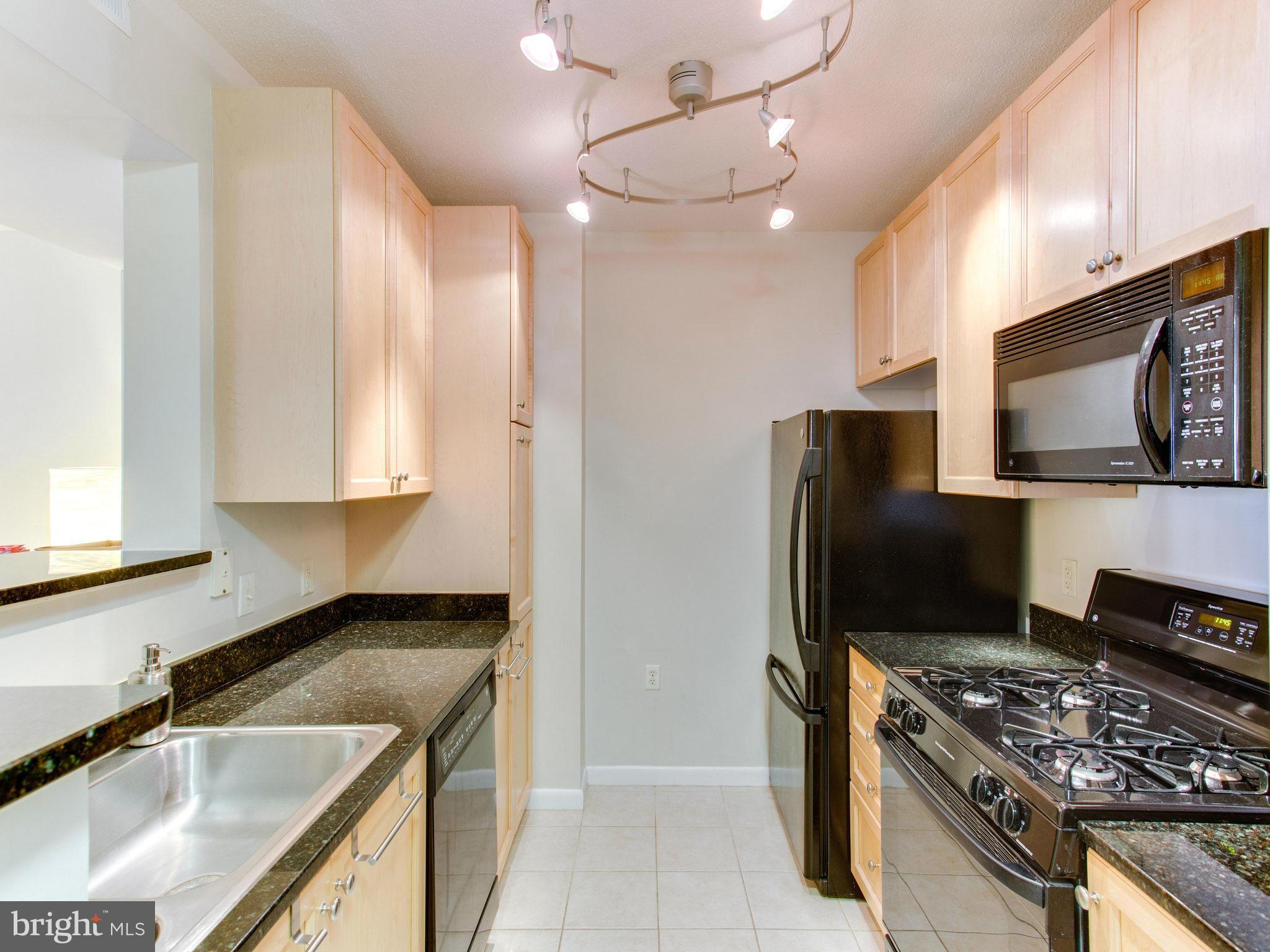 851 North Glebe Road, Unit 403 Arlington, VA 22203 - Photo 5 of 28 a kitchen with stainless steel appliances granite countertop a sink stove and refrigerator