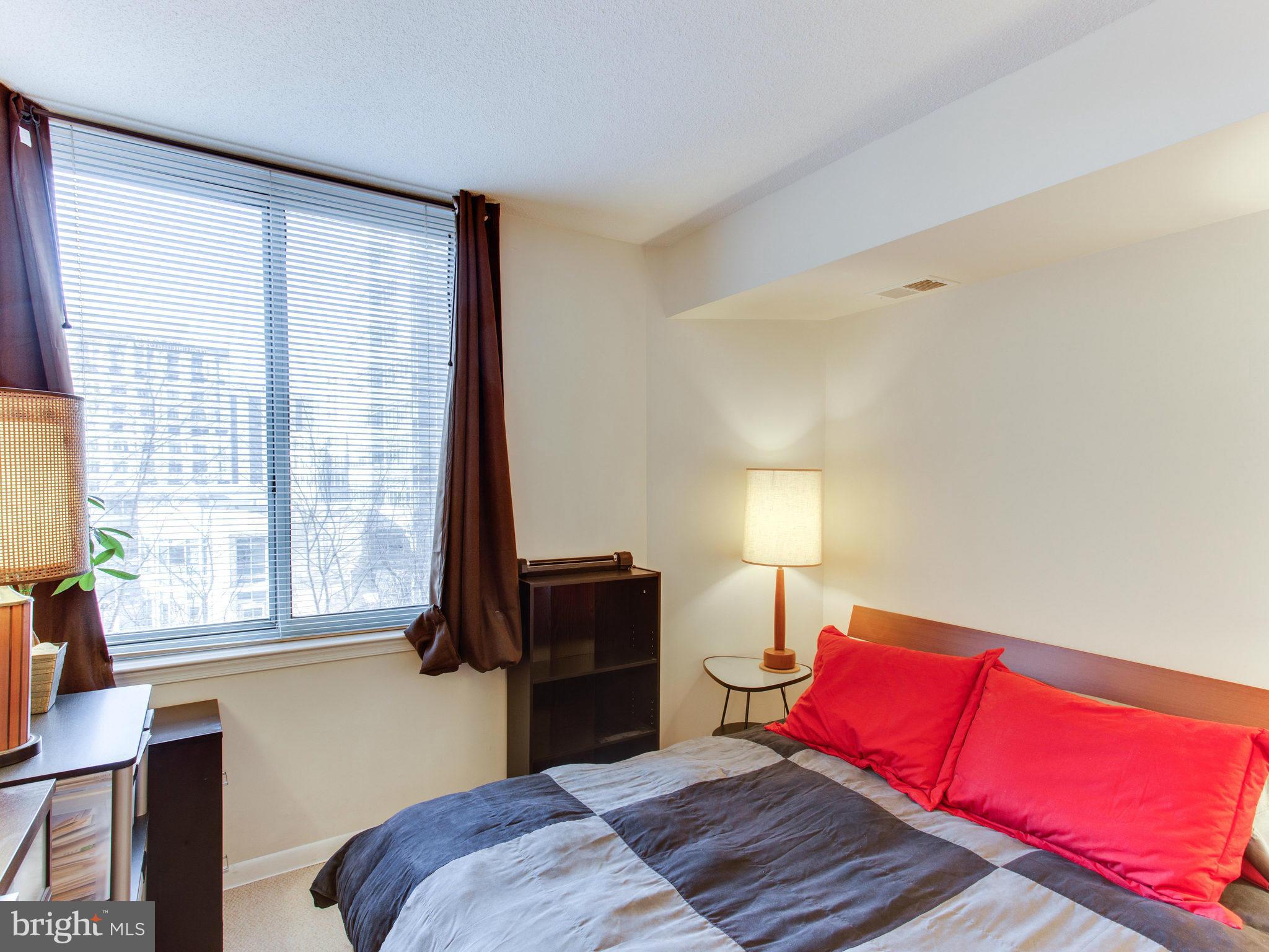 851 North Glebe Road, Unit 403 Arlington, VA 22203 - Photo 9 of 28 a bedroom with a bed and window with chair