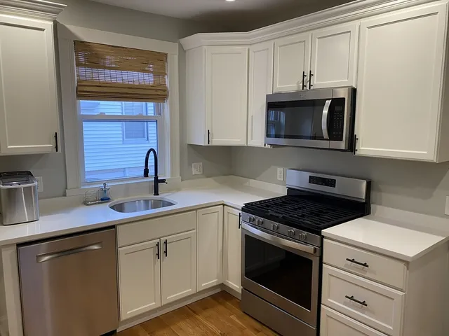 a kitchen with cabinets stainless steel appliances and a sink