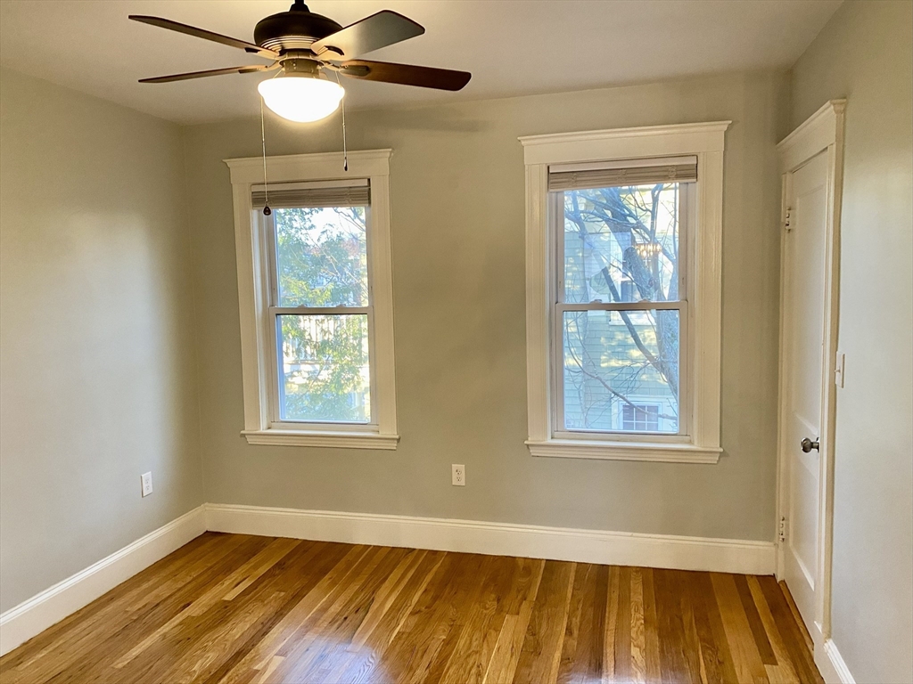 281 Belgrade Avenue, Unit 3 Boston, MA 02131 - Photo 11 of 14 a view of an empty room with wooden floor and a window