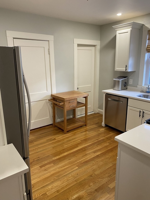281 Belgrade Avenue, Unit 3 Boston, MA 02131 - Photo 3 of 14 a view of a kitchen with wooden floor and electronic appliances