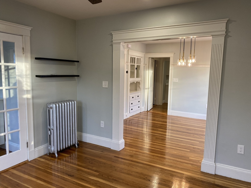 281 Belgrade Avenue, Unit 3 Boston, MA 02131 - Photo 10 of 14 a view of a hallway with wooden floor and staircase