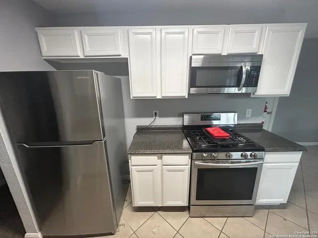 a kitchen with stainless steel appliances a stove a microwave and a refrigerator