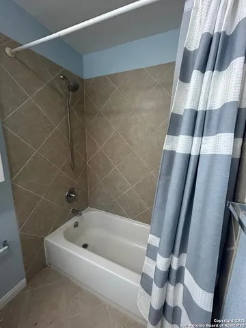 a bathroom with a bathtub and shower