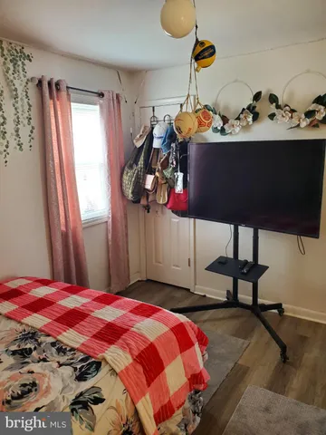 a bedroom with a bed a dresser and window