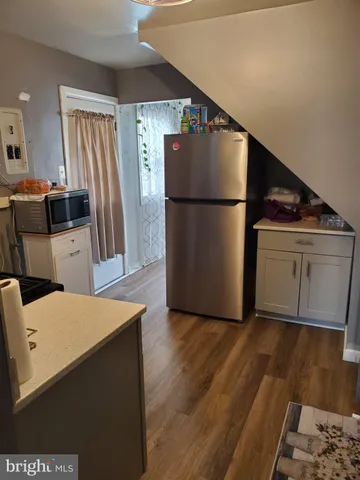 a kitchen with stainless steel appliances a refrigerator and wooden floor
