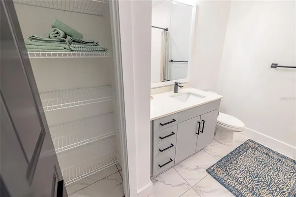 a bedroom with a bed a chandelier and dresser