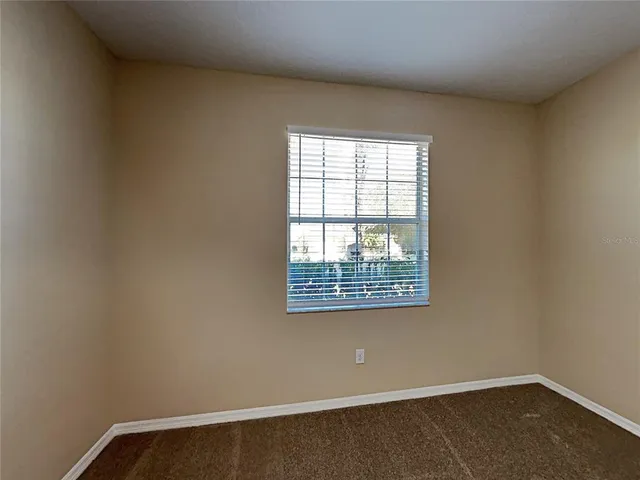 a view of a room with wooden floor and a window