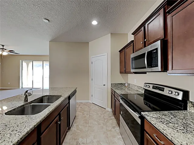 a kitchen with granite countertop a sink and a stove top oven