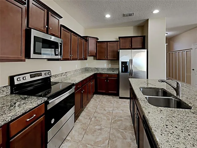 a kitchen with a sink a microwave and refrigerator