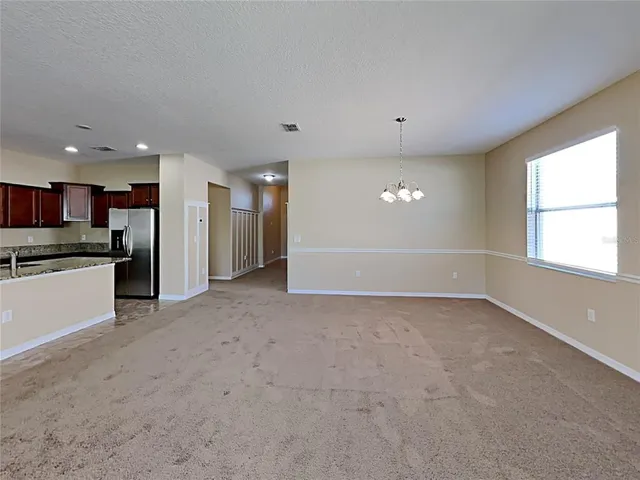an empty room with cabinet and windows