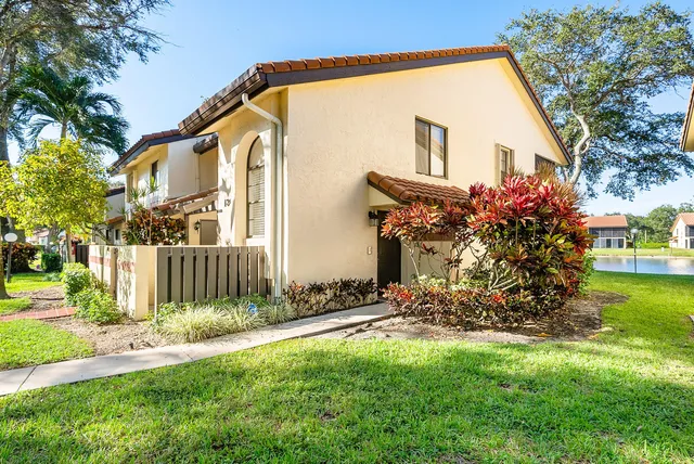a view of a house with backyard and a tree