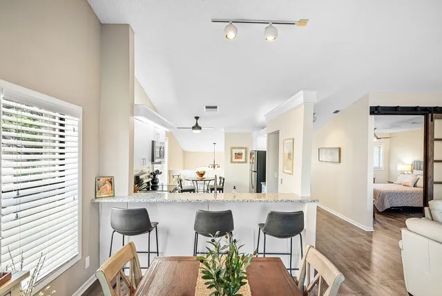 a living room with stainless steel appliances kitchen island granite countertop furniture and a large window