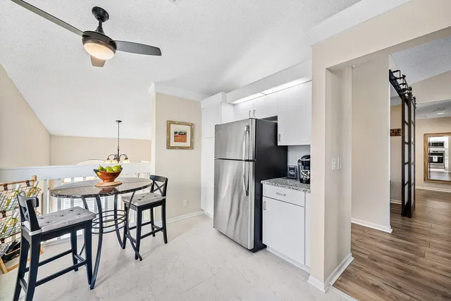 a kitchen with stainless steel appliances a refrigerator a table and chairs