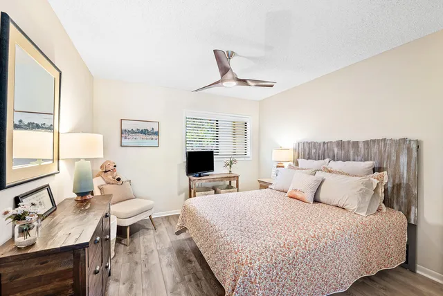 a bedroom with a bed a desk and chair with window