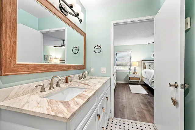 a en suite bathroom with a granite countertop sink and a mirror