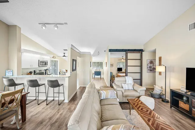 a living room with furniture a flat screen tv and a table