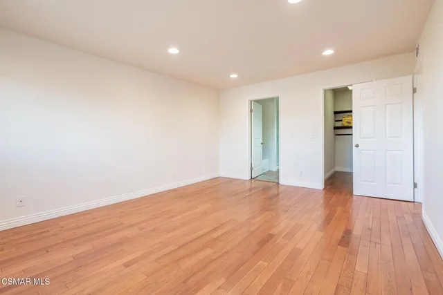 a view of empty room with wooden floor