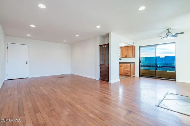 a view of empty room with wooden floor and windows
