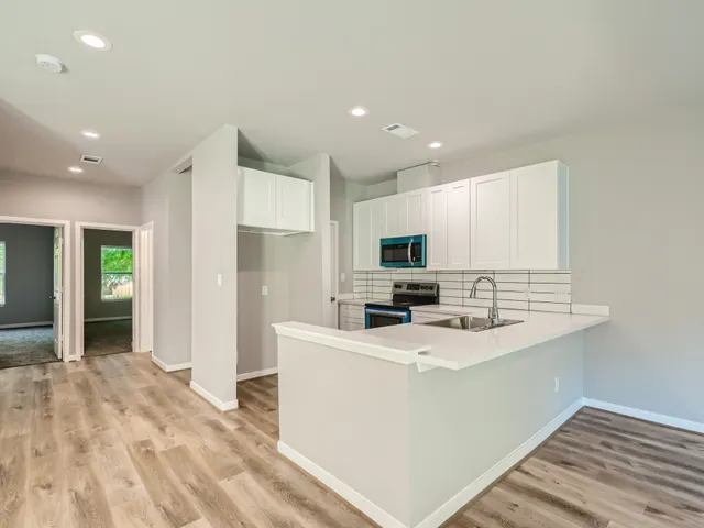 a view of a kitchen with a sink and a refrigerator