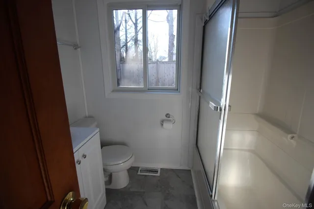 a bathroom with a toilet and a shower