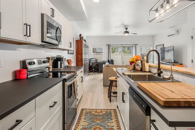 a kitchen with stainless steel appliances granite countertop a sink dishwasher stove and cabinets