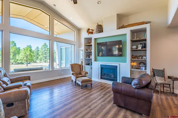 a living room with furniture a fireplace and a large window