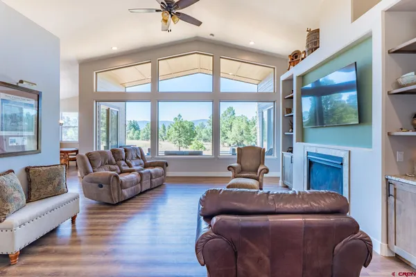 a living room with furniture a large window and a flat screen tv