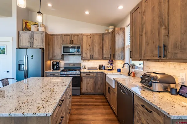 a kitchen with kitchen island granite countertop a sink stove and refrigerator