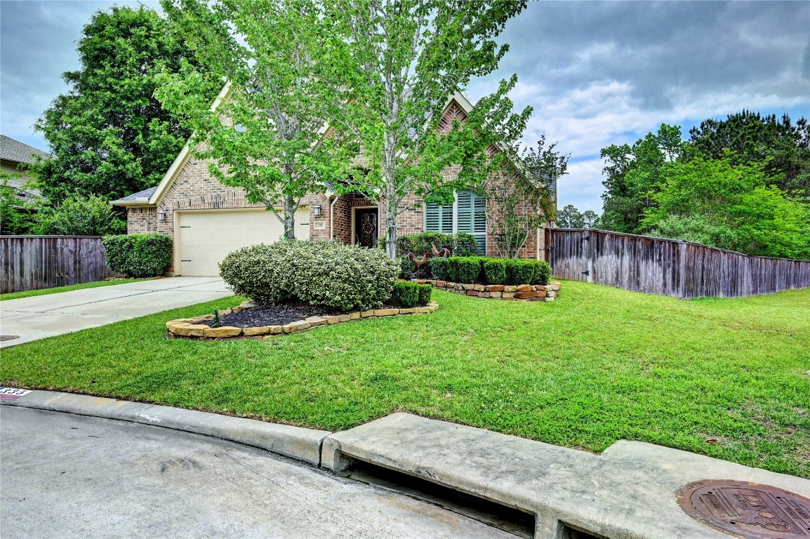 335 Fox Trail Road Montgomery, TX 77316 - Photo 2 of 47 Charming brick home with a well-maintained front yard. Features a two-car garage, mature trees, and neatly trimmed shrubs. Located on a quiet street with a wooden fence for added privacy.