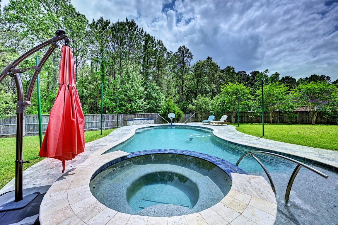 335 Fox Trail Road Montgomery, TX 77316 - Photo 29 of 47 This backyard features a spacious pool with a connected spa, surrounded by a lush lawn and mature trees for privacy. Ideal for relaxing and entertaining. Pool depth is approx. 3.5-5.5 , length 40ft/width 19ft.