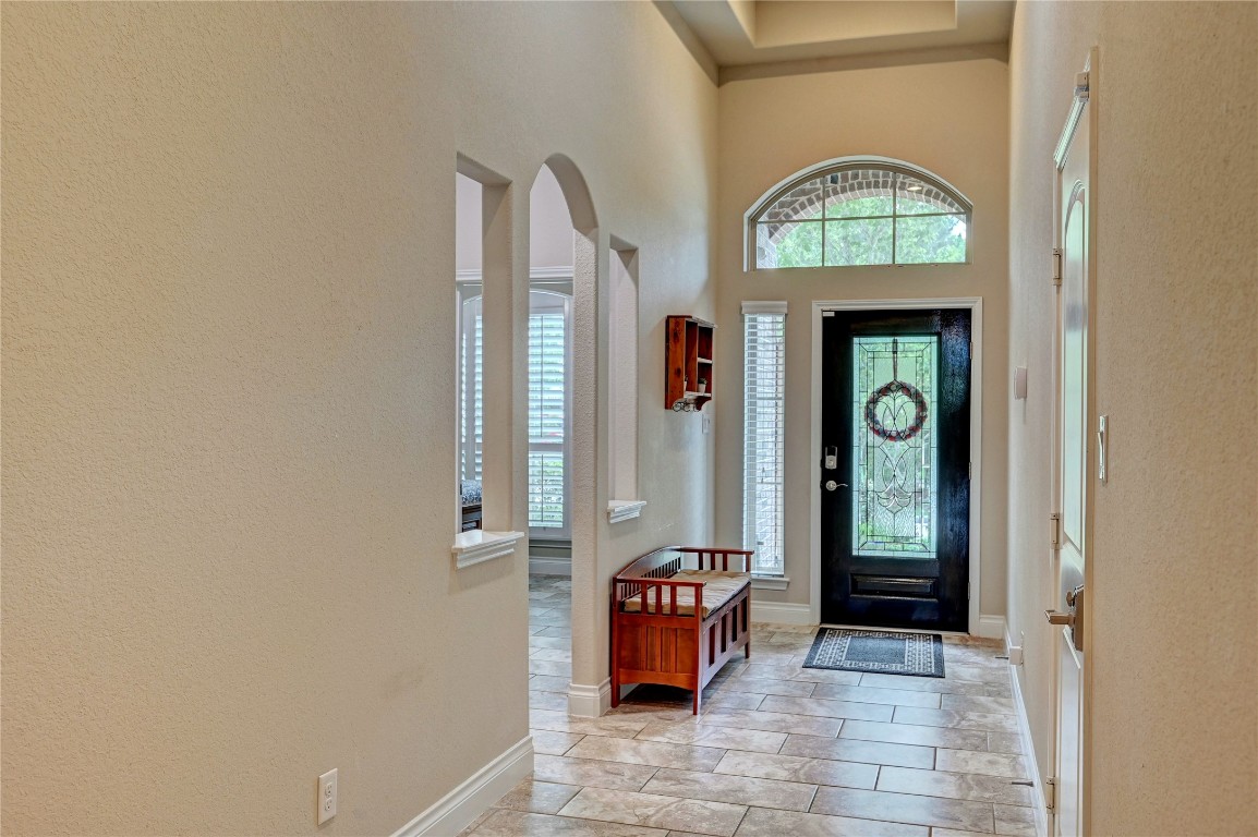 335 Fox Trail Road Montgomery, TX 77316 - Photo 41 of 47 This inviting extended entryway features a stylish black front door with decorative glass, high ceilings, and tile flooring. Natural light streams in through the arched window, enhancing the space's warm and welcoming ambiance.