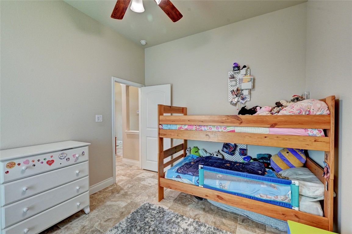 335 Fox Trail Road Montgomery, TX 77316 - Photo 44 of 47 This secondary bedroom features tiled flooring , neutral walls, and a ceiling fan, providing a welcoming and functional space.