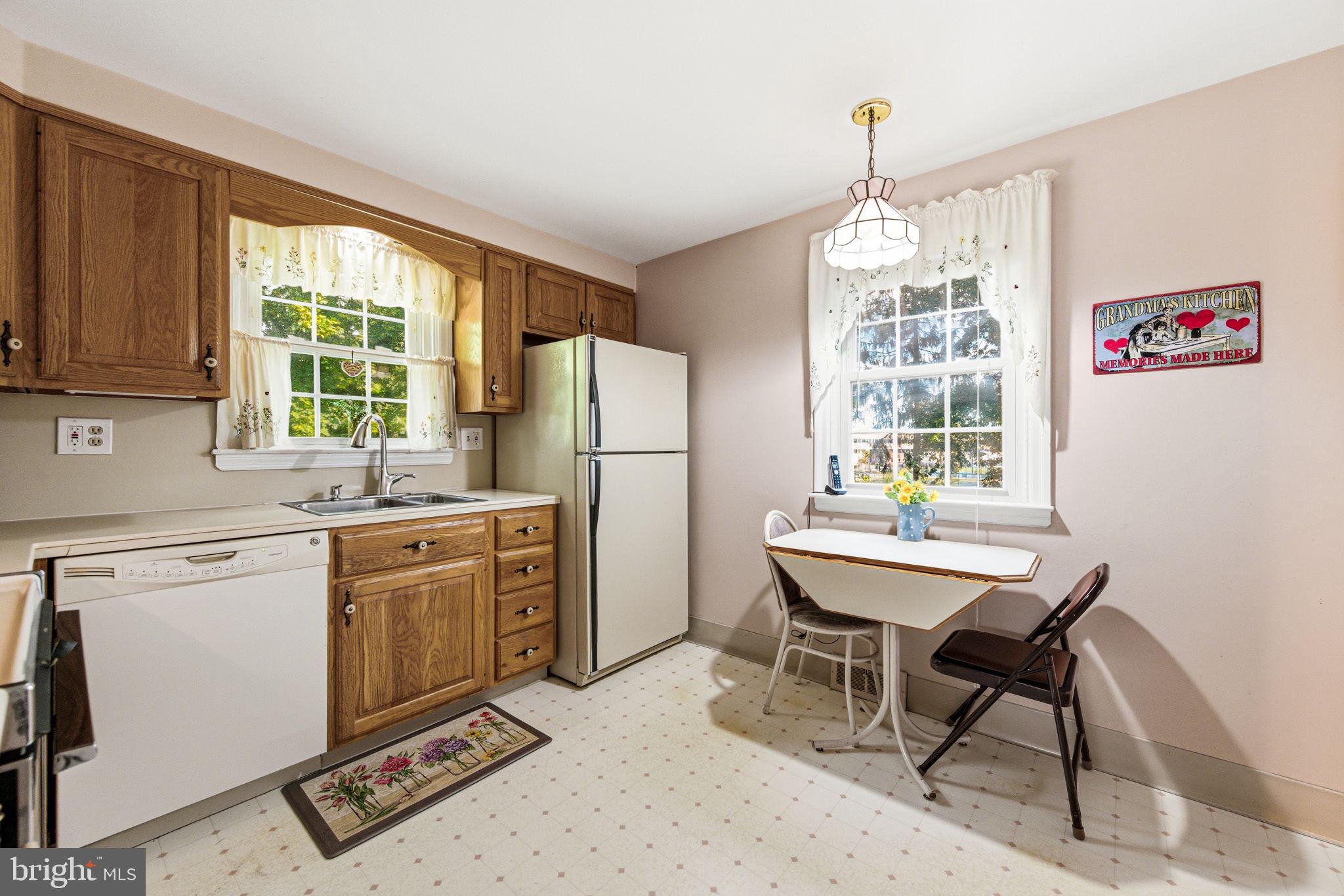 247 Orchard Road Springfield, PA 19064 - Photo 12 of 30 a kitchen with stainless steel appliances granite countertop a stove a refrigerator with a dining table and chairs