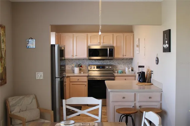 a kitchen with stainless steel appliances a stove a sink refrigerator and microwave