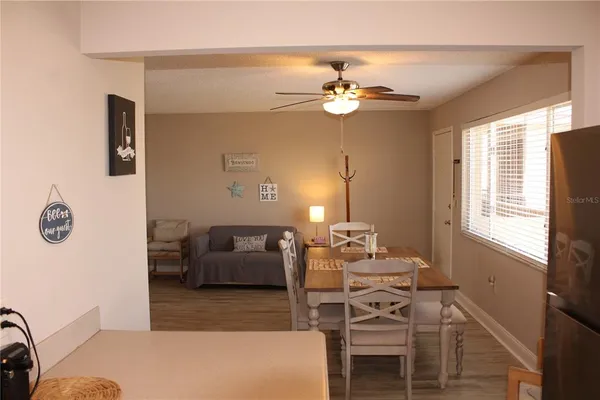 a living room with a table and chair with wooden floor