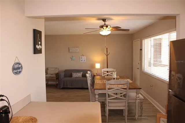 a living room with a table and chair with wooden floor