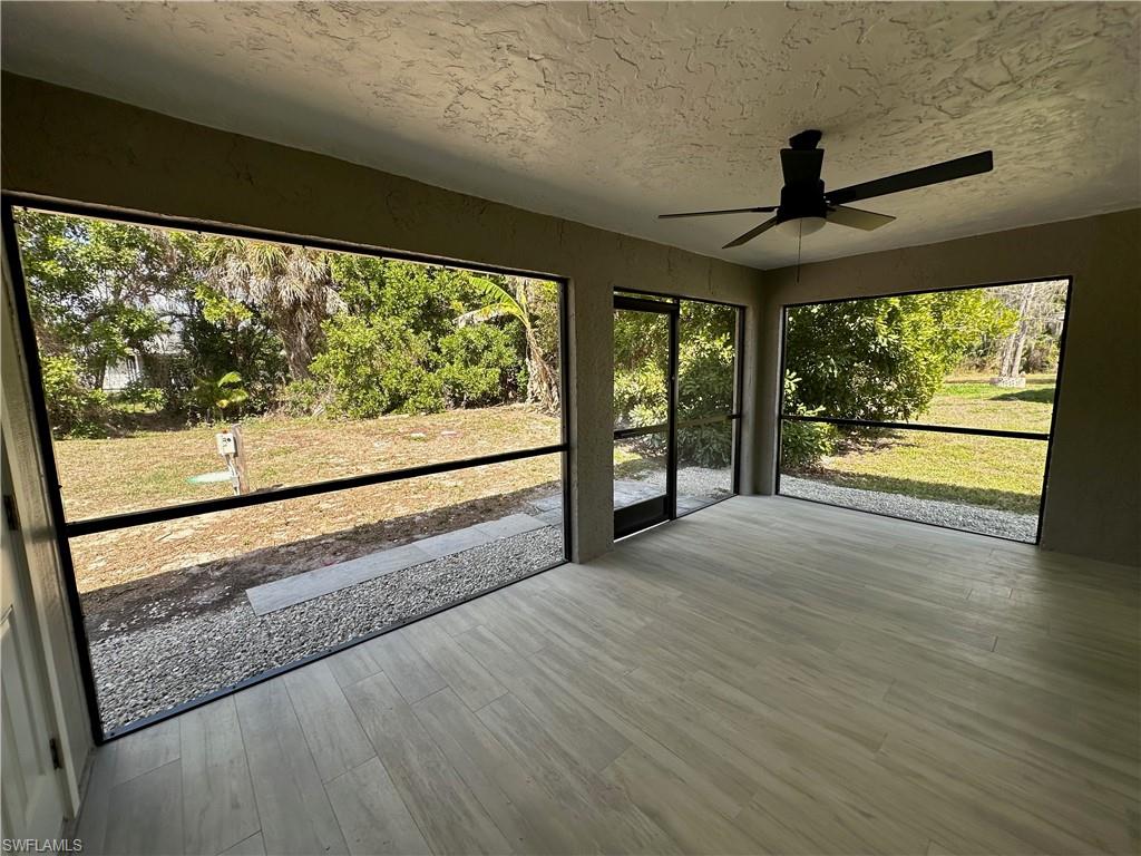 9165 Seville Road Fort Myers, FL 33967 - Photo 16 of 19 a view of an empty room with wooden floor and a window