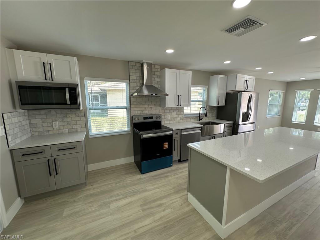 9165 Seville Road Fort Myers, FL 33967 - Photo 5 of 19 a kitchen with stainless steel appliances granite countertop a sink stove refrigerator and cabinets