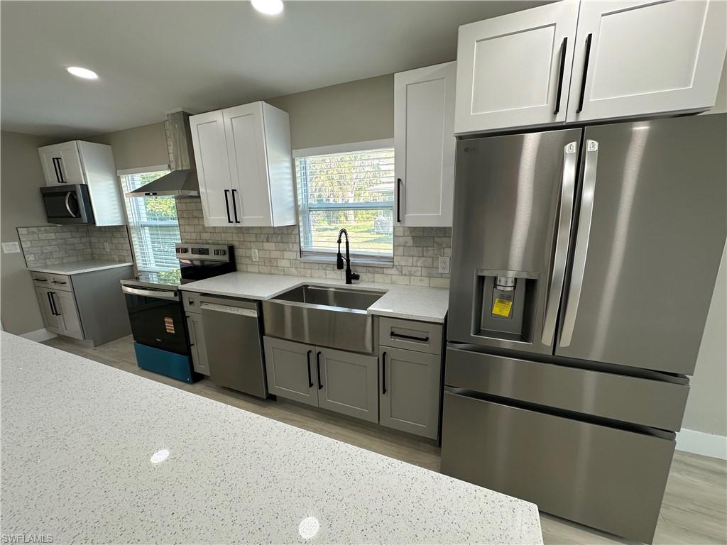 9165 Seville Road Fort Myers, FL 33967 - Photo 7 of 19 a kitchen with stainless steel appliances a refrigerator a sink a stove a microwave a sink and cabinets