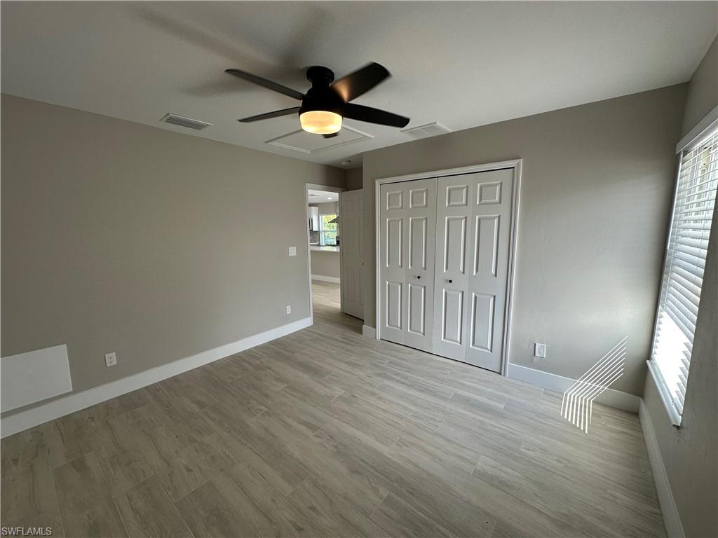 9165 Seville Road Fort Myers, FL 33967 - Photo 10 of 19 an empty room with wooden floor and windows