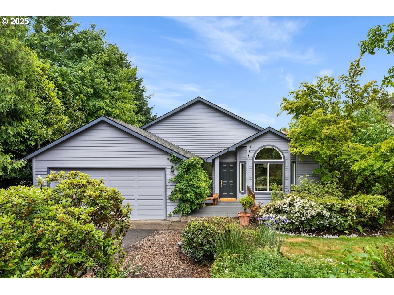 a front view of a house with a yard and potted plants