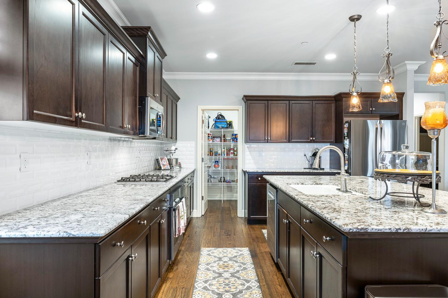 3293 Soledad Avenue Clovis, CA 93619 - Photo 12 of 37 a kitchen with granite countertop stainless steel appliances a sink stove and cabinets